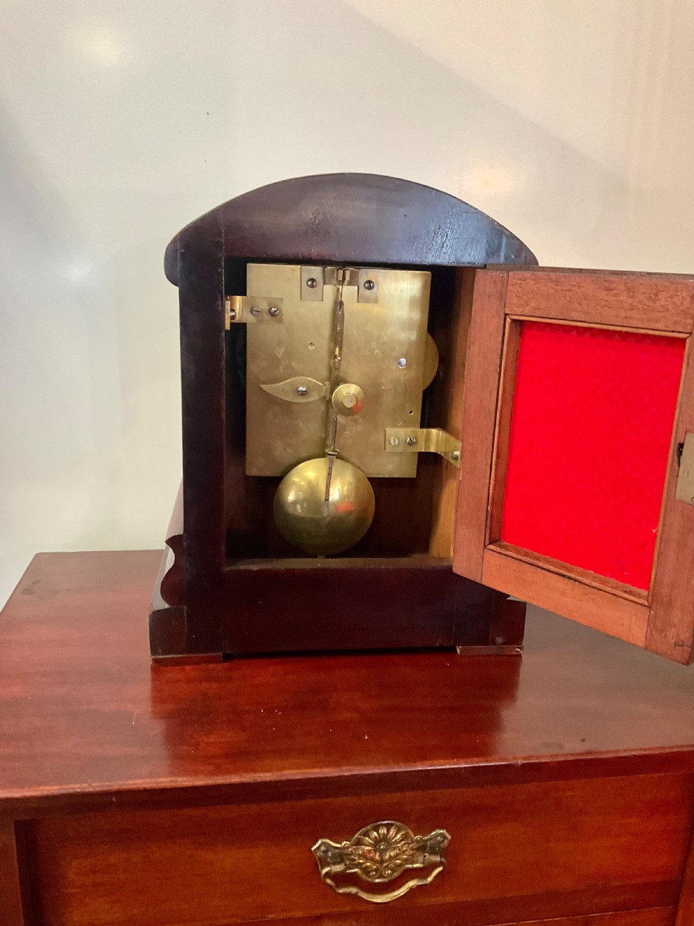 A 19th-century mahogany fusee bracket clock featuring an arched case with hand-carved floral spandrels, flame mahogany veneer, and a circular cream dial with Roman numerals. View X