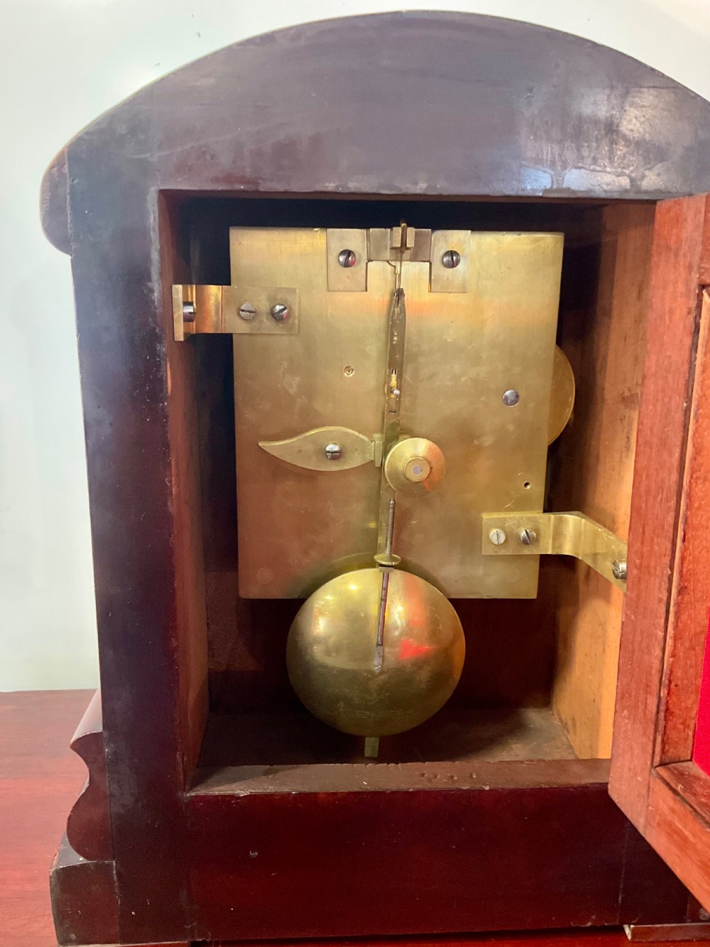 A 19th-century mahogany fusee bracket clock featuring an arched case with hand-carved floral spandrels, flame mahogany veneer, and a circular cream dial with Roman numerals. View XI