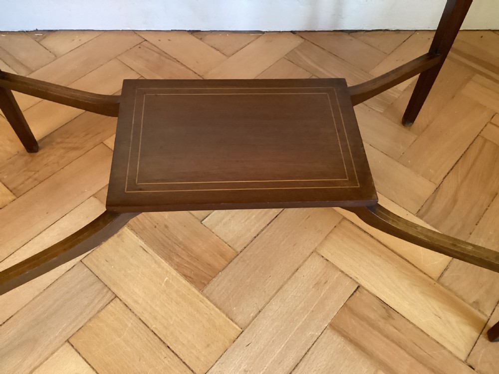 An Edwardian mahogany bijouterie table with glass display panels, satinwood inlay, gold fabric lining, and tapered legs joined by an undertier. View II