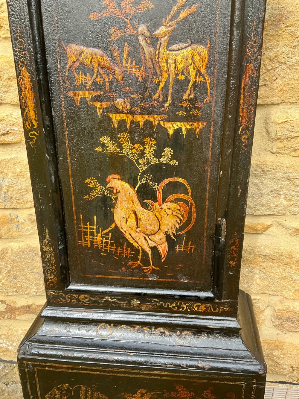 An early Georgian black japanned longcase clock featuring raised gilt Chinoiserie landscapes and figures on the case door, topped with an arched brass dial. View III