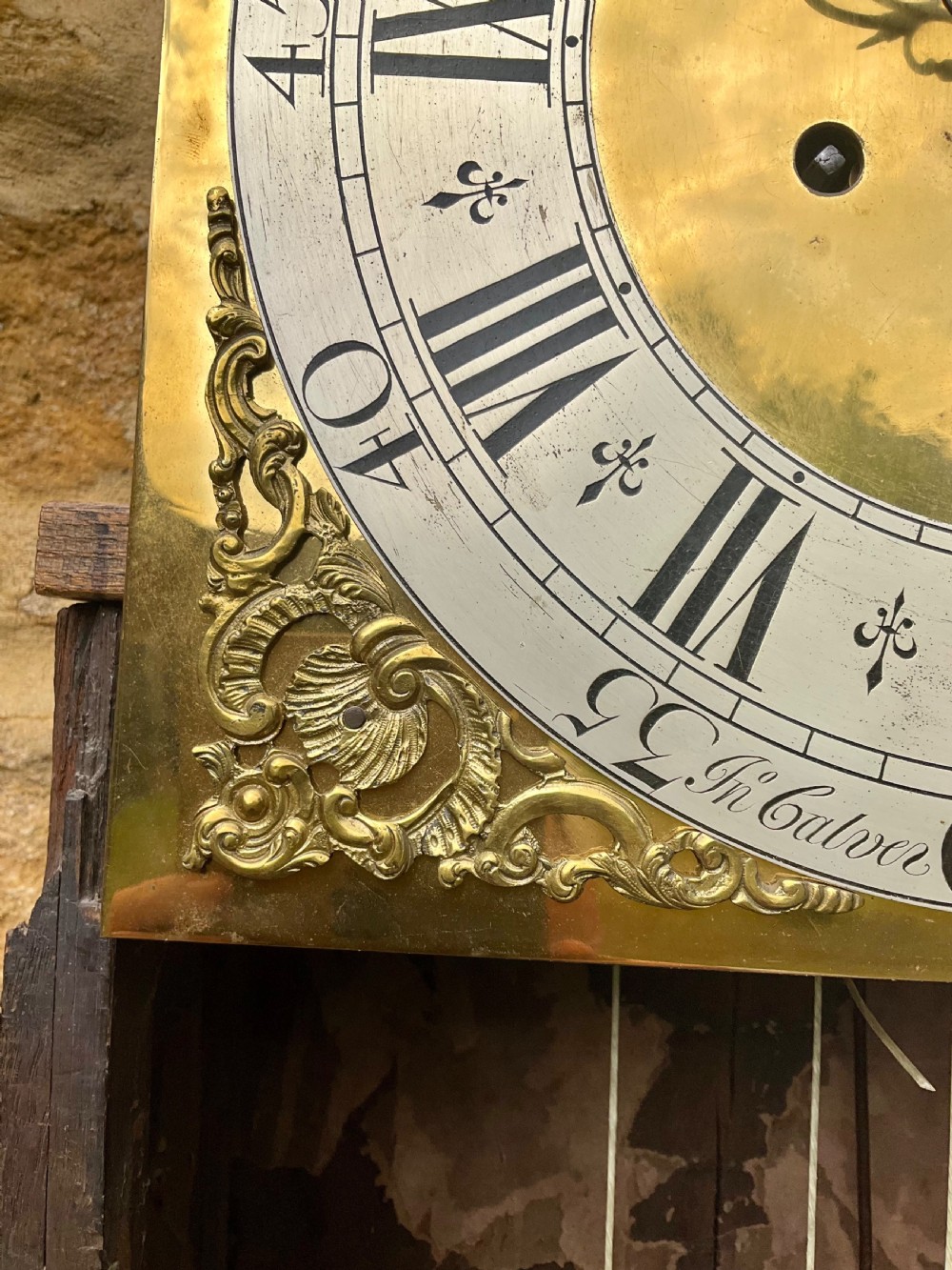 An early Georgian black japanned longcase clock featuring raised gilt Chinoiserie landscapes and figures on the case door, topped with an arched brass dial. View XII