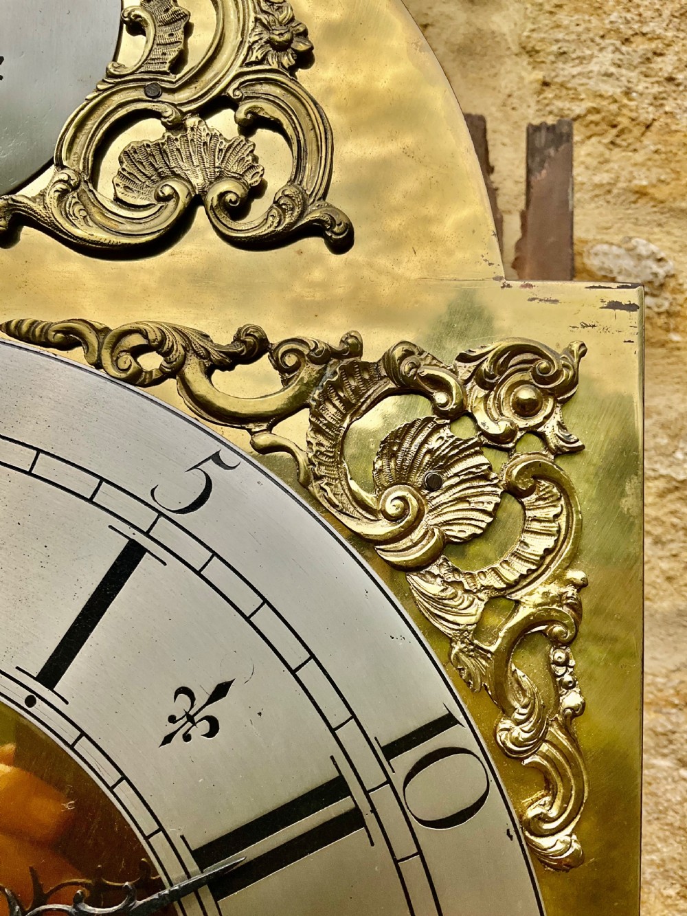 An early Georgian black japanned longcase clock featuring raised gilt Chinoiserie landscapes and figures on the case door, topped with an arched brass dial. View XIII