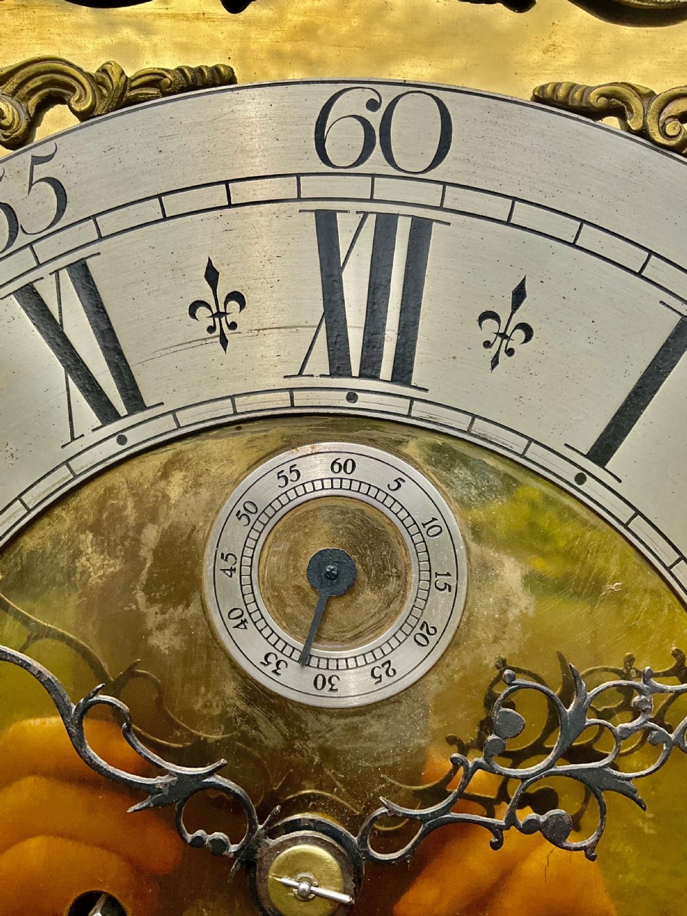 An early Georgian black japanned longcase clock featuring raised gilt Chinoiserie landscapes and figures on the case door, topped with an arched brass dial. View XIV
