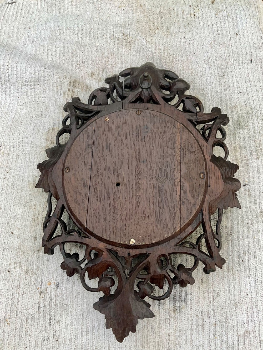 A 19th-century Black Forest aneroid barometer featuring a carved dark wood frame with leaf and acorn motifs surrounding a circular white ceramic dial. View XI