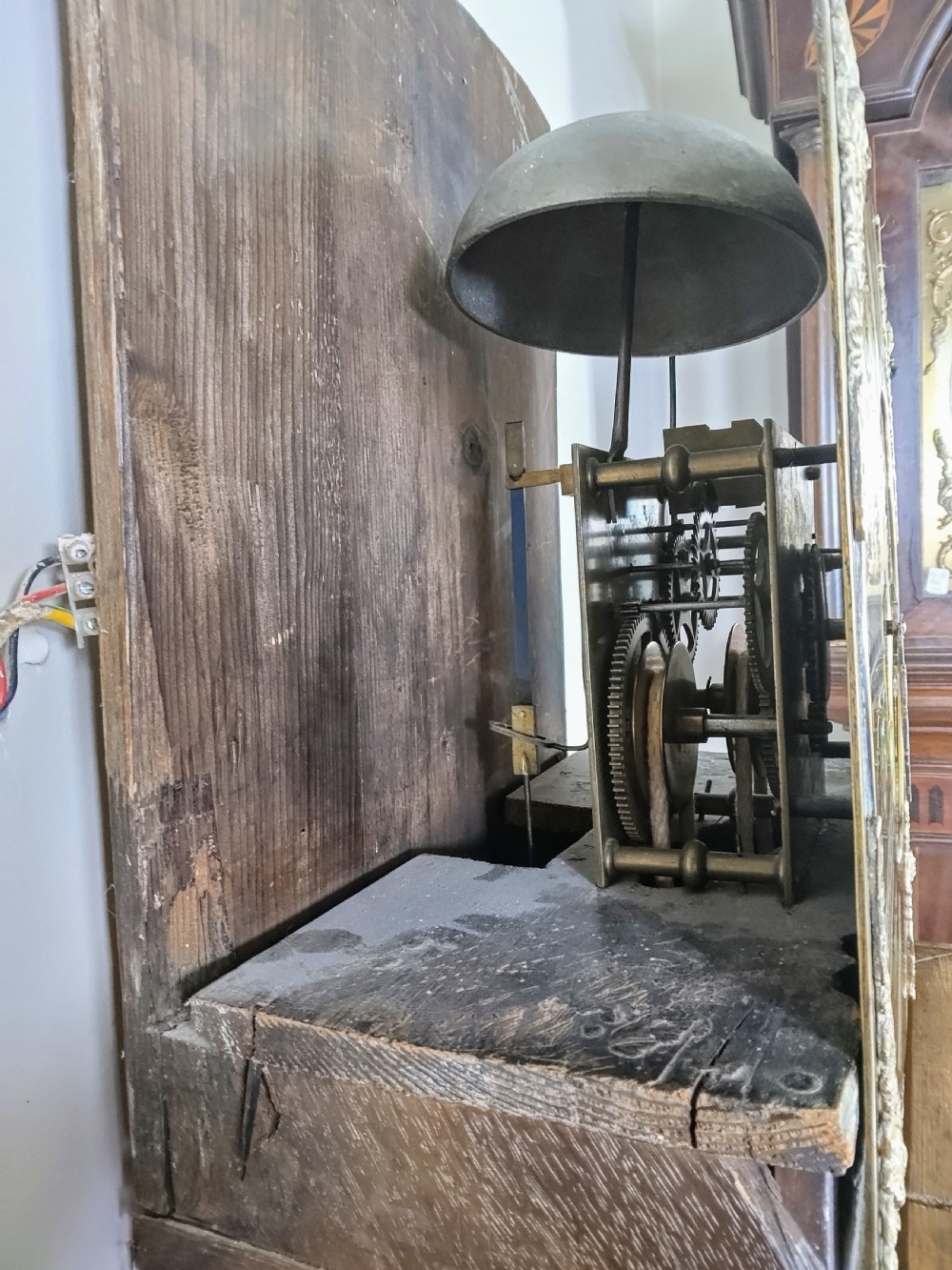 An 18th-century oak longcase clock with an eleven-inch square brass dial, turned hood columns, and a plain wooden trunk door. View XIX