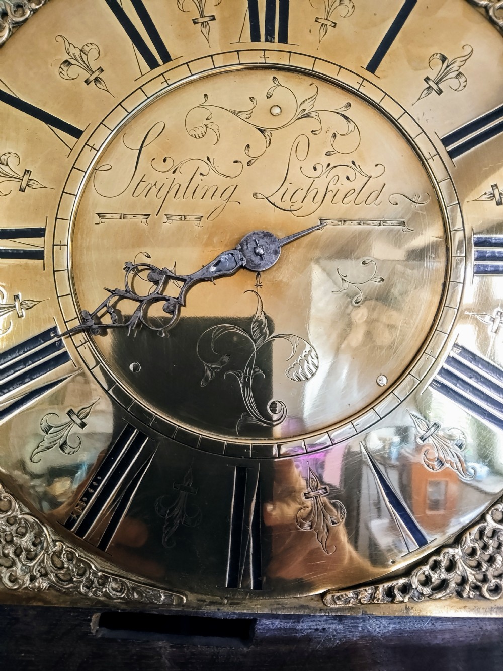 An 18th-century oak longcase clock with an eleven-inch square brass dial, turned hood columns, and a plain wooden trunk door. View XX