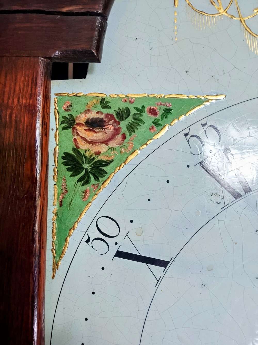 A Georgian oak and mahogany longcase clock featuring a swan-neck pediment, brass patera ornaments, fluted columns, and a painted arch dial. View IV