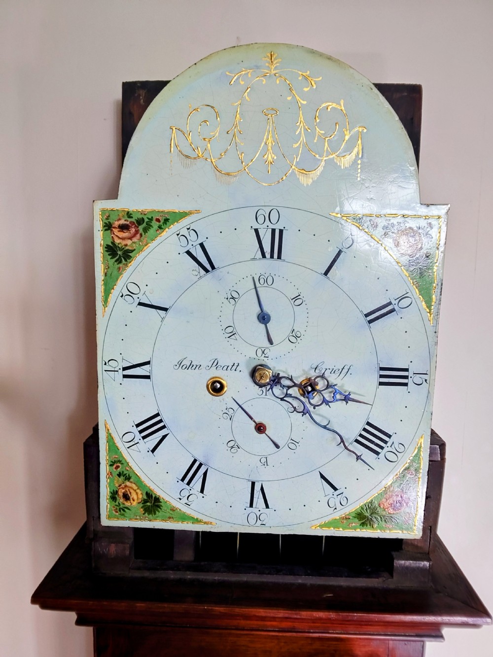 A Georgian oak and mahogany longcase clock featuring a swan-neck pediment, brass patera ornaments, fluted columns, and a painted arch dial. View XII