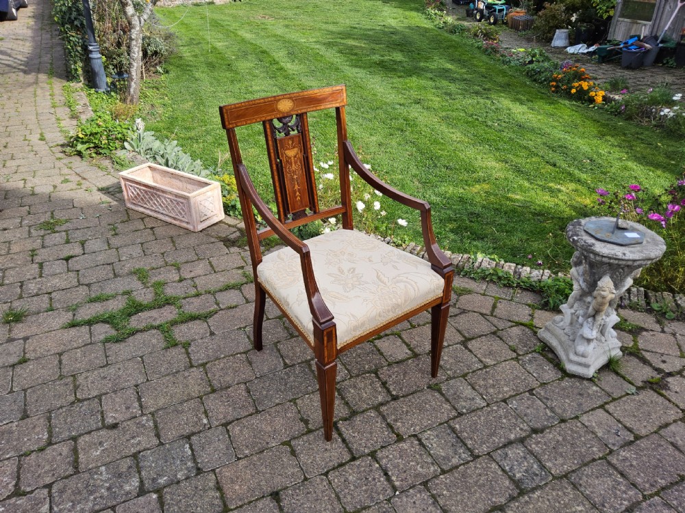 An Edwardian mahogany elbow chair featuring decorative marquetry inlay on the backrest splat and a light patterned upholstered seat. View VIII