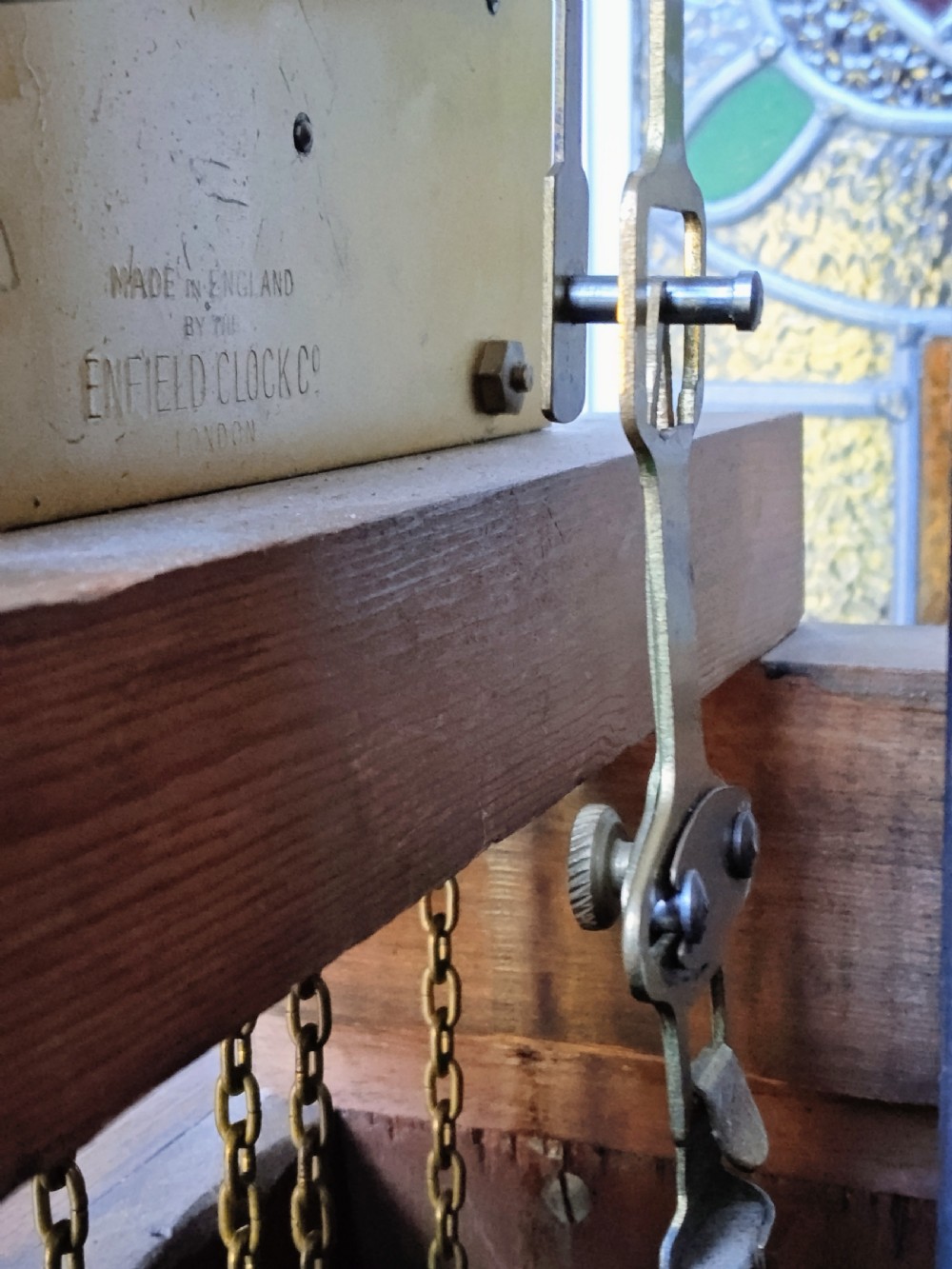 A slim mahogany grandmother longcase clock with a carved top frieze, brass Roman numeral dial, and an arched waist door. View XIII