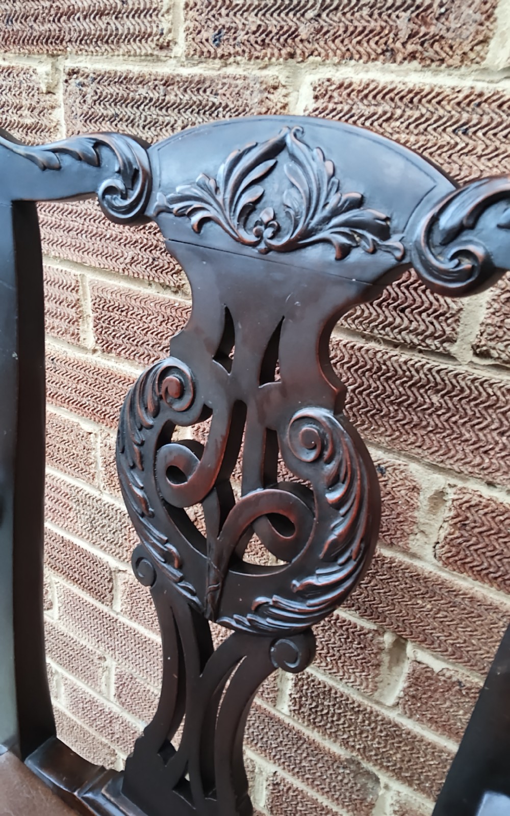 A dark mahogany elbow chair featuring a carved pierced splat back, shaped arms, a brown leather seat, and cabriole legs with ball and claw feet. View V