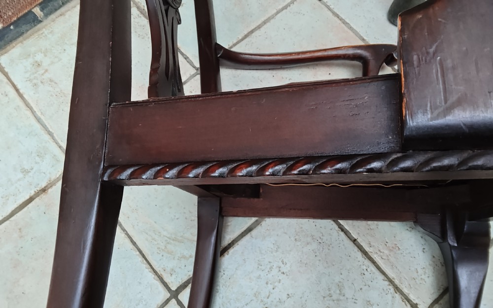 A dark mahogany elbow chair featuring a carved pierced splat back, shaped arms, a brown leather seat, and cabriole legs with ball and claw feet. View VI