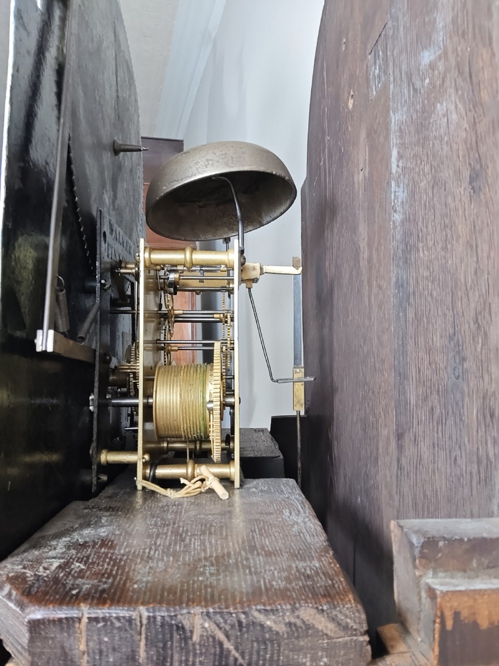 A Georgian flame mahogany longcase clock featuring a painted dial with moon phase indicator, swan-neck pediment, brass finials, and fluted columns. View XVIII