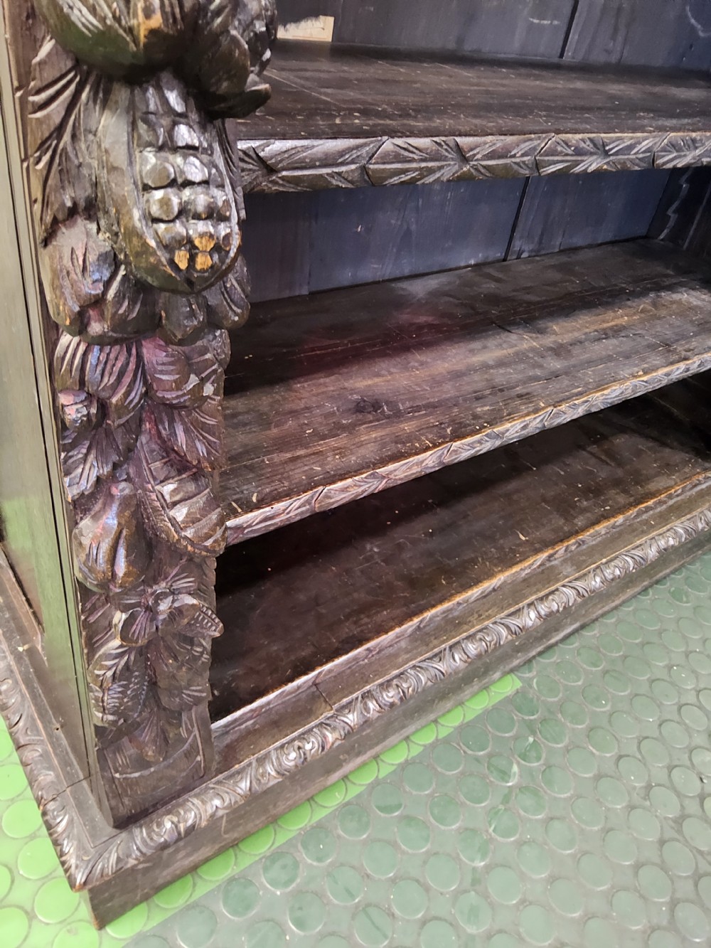 A dark oak Victorian open bookcase featuring hand-carved floral friezes, fruit garlands along the side columns, and adjustable shelving. View V