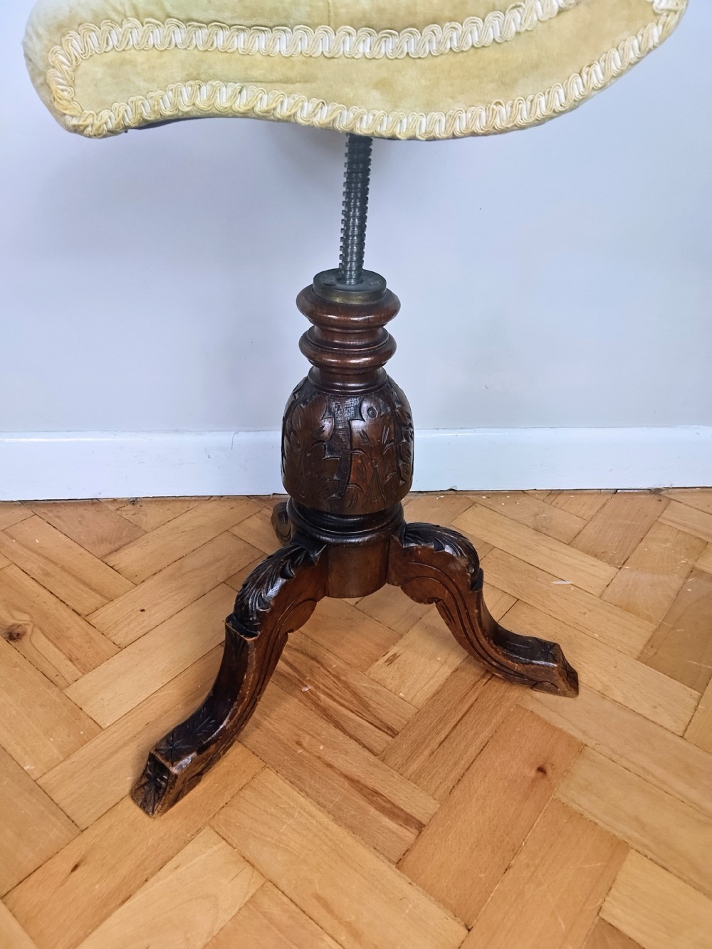 Victorian carved walnut swivel piano stool featuring a button-tufted olive green velvet seat with decorative braid trim and a low curved backrest. View III