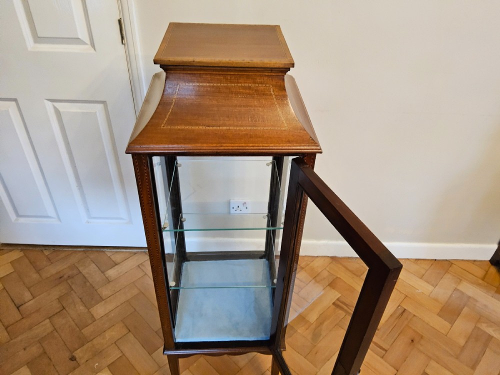 A slender mahogany bijouterie cabinet featuring four glass sides, two glass shelves, satinwood inlay details, and a stepped pagoda top. View VII