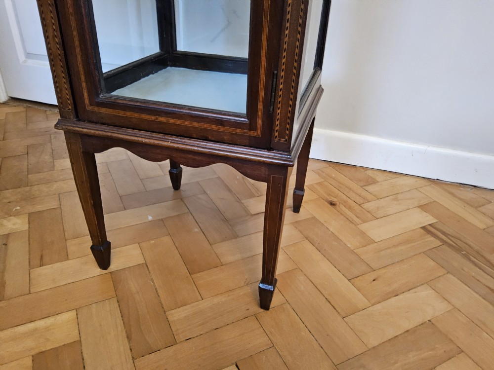 A slender mahogany bijouterie cabinet featuring four glass sides, two glass shelves, satinwood inlay details, and a stepped pagoda top. View V