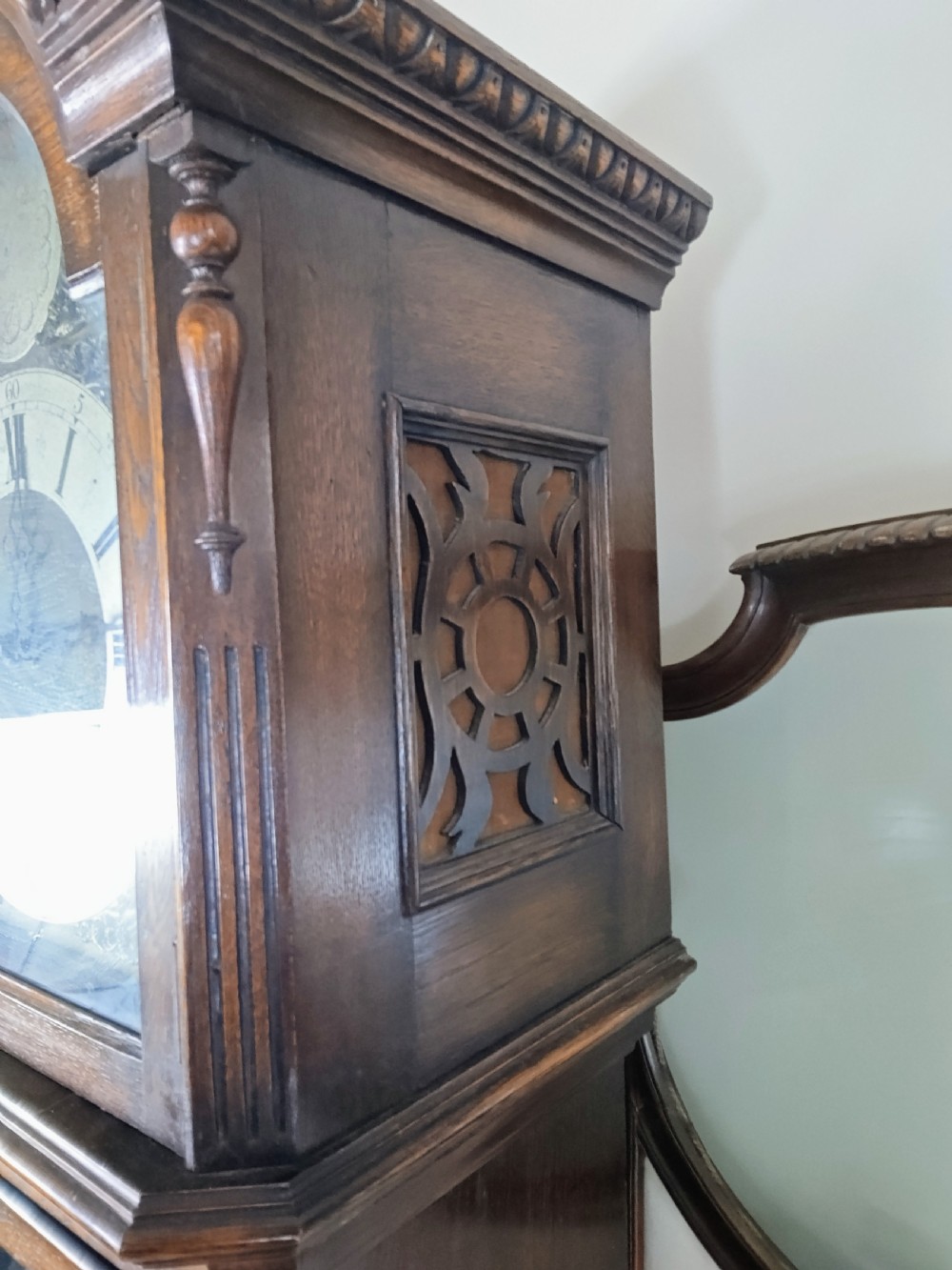 A dark oak longcase clock featuring an arched hood, a brass dial with silvered chapter ring, and an astragal glazed trunk door. View II