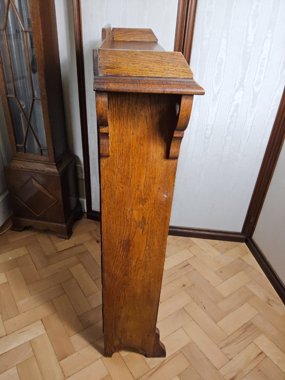 An Arts and Crafts solid oak open bookcase featuring three shelves and heart-shaped cutouts on the top gallery and side brackets. View VI
