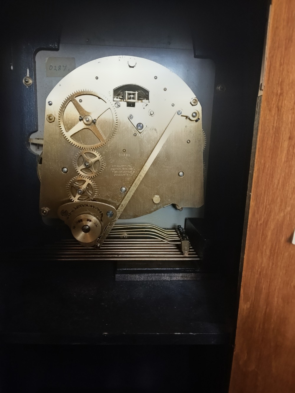 A freestanding burr walnut grandmother clock featuring an arched hood, brass dial with Roman numerals, and a figure-matched veneered trunk. View IV