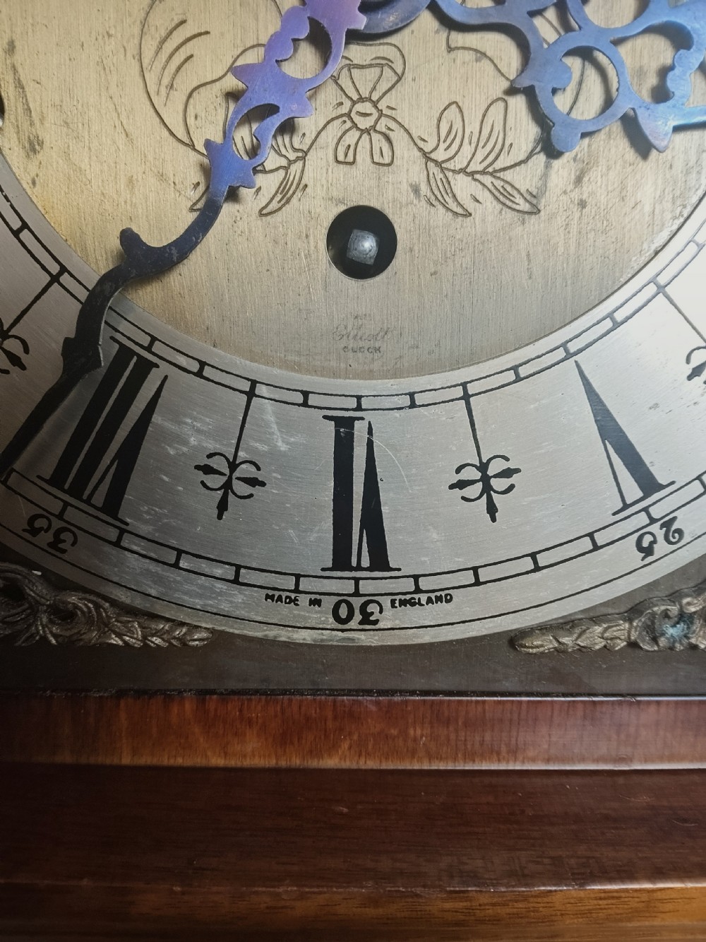 A freestanding burr walnut grandmother clock featuring an arched hood, brass dial with Roman numerals, and a figure-matched veneered trunk. View XI
