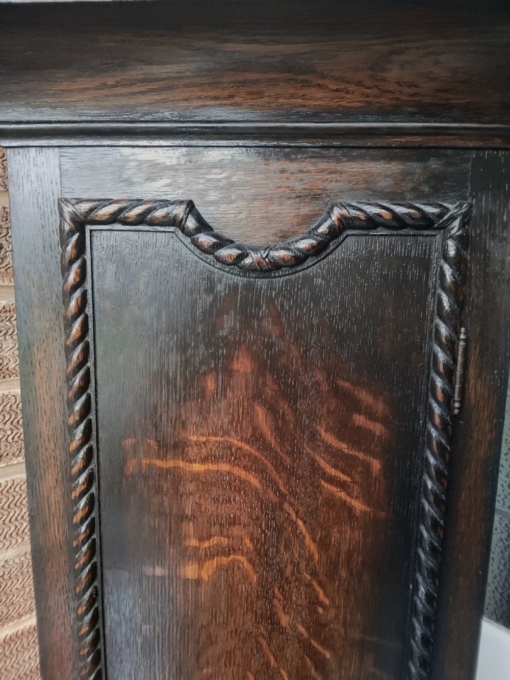 A tall dark oak longcase clock featuring rope twist columns, a square brass dial with silvered chapter ring, and a carved wooden casing. View III
