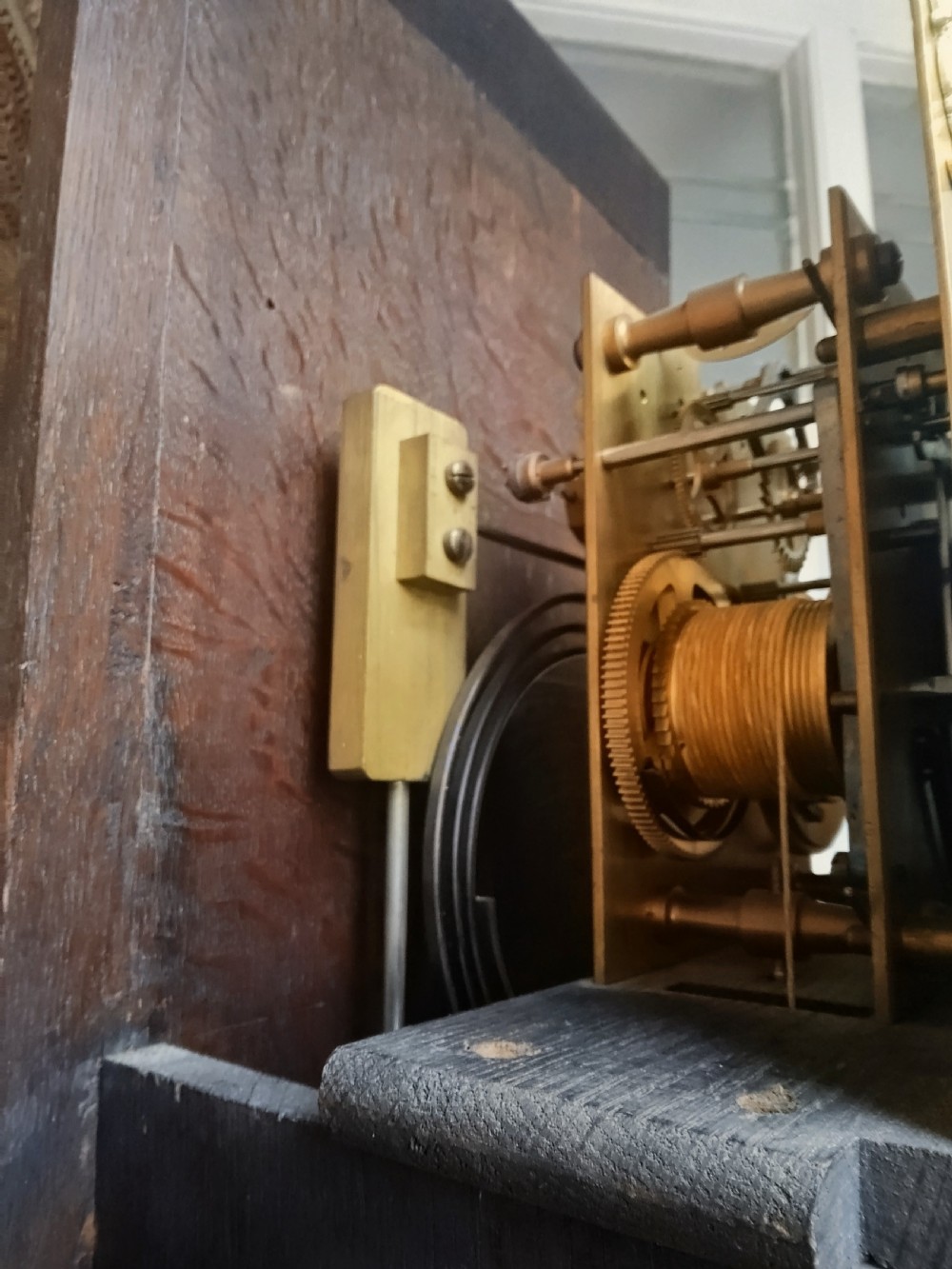 A tall dark oak longcase clock featuring rope twist columns, a square brass dial with silvered chapter ring, and a carved wooden casing. View XIII