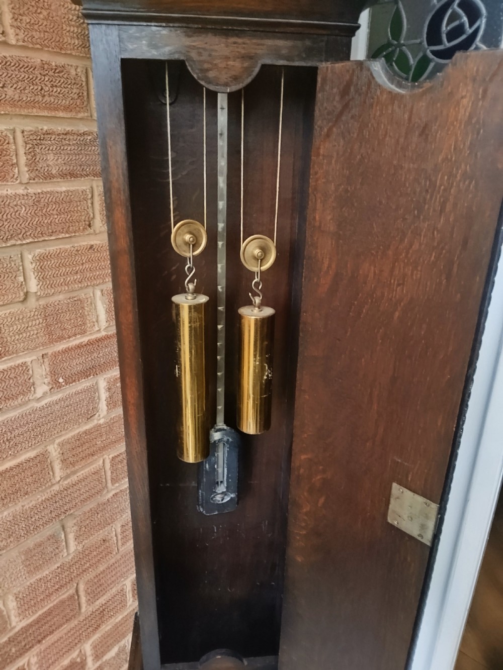 A tall dark oak longcase clock featuring rope twist columns, a square brass dial with silvered chapter ring, and a carved wooden casing. View XIV