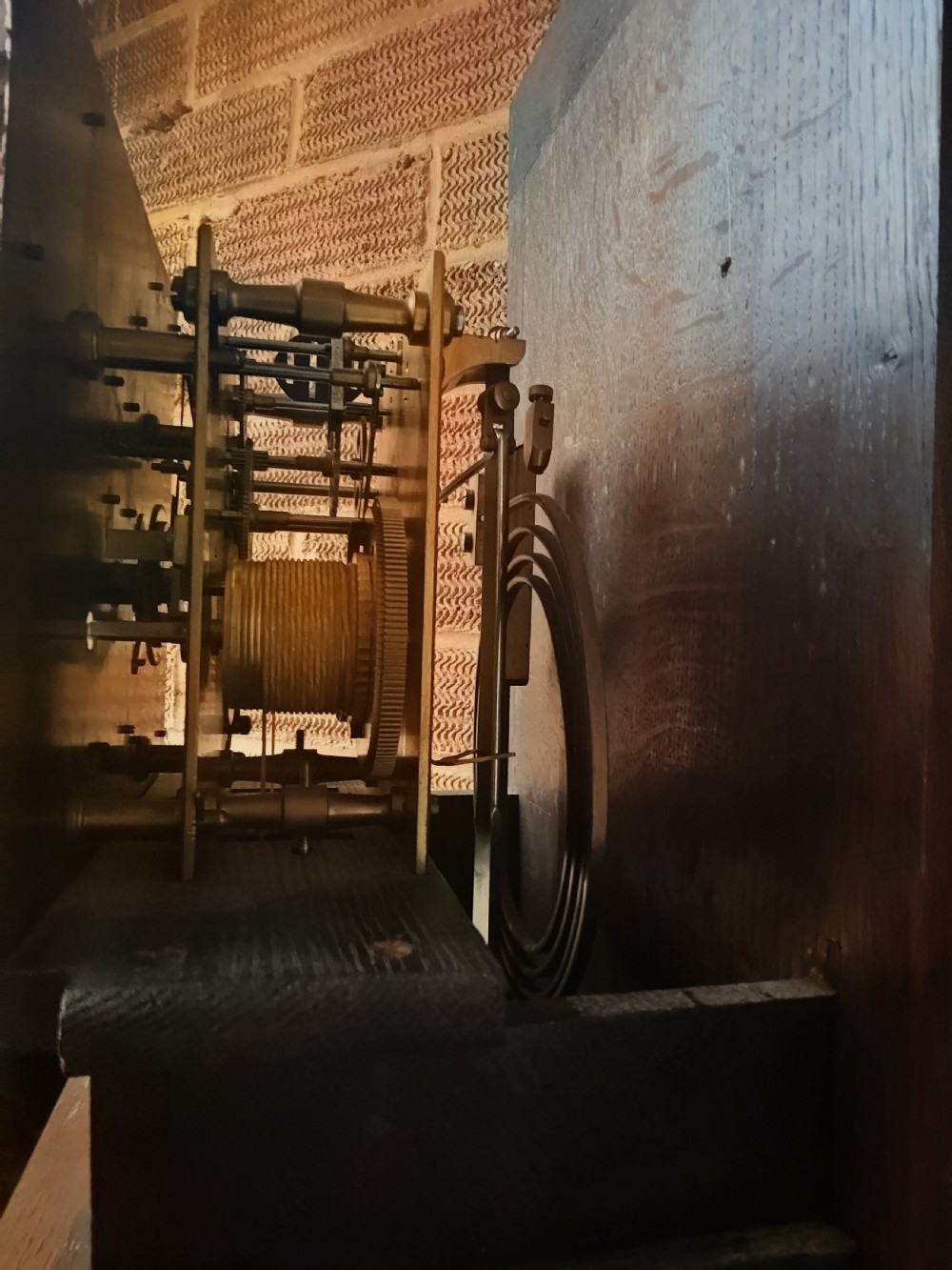 A tall dark oak longcase clock featuring rope twist columns, a square brass dial with silvered chapter ring, and a carved wooden casing. View XVI