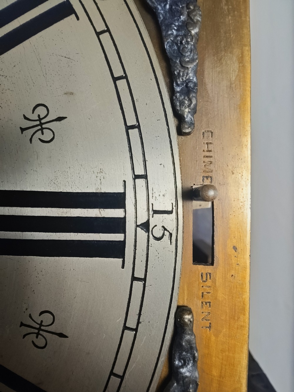 A tall dark oak longcase clock featuring an arched bonnet, barley twist side columns, a brass dial with Roman numerals, and a glazed trunk door displaying three brass weights and pendulum. View X