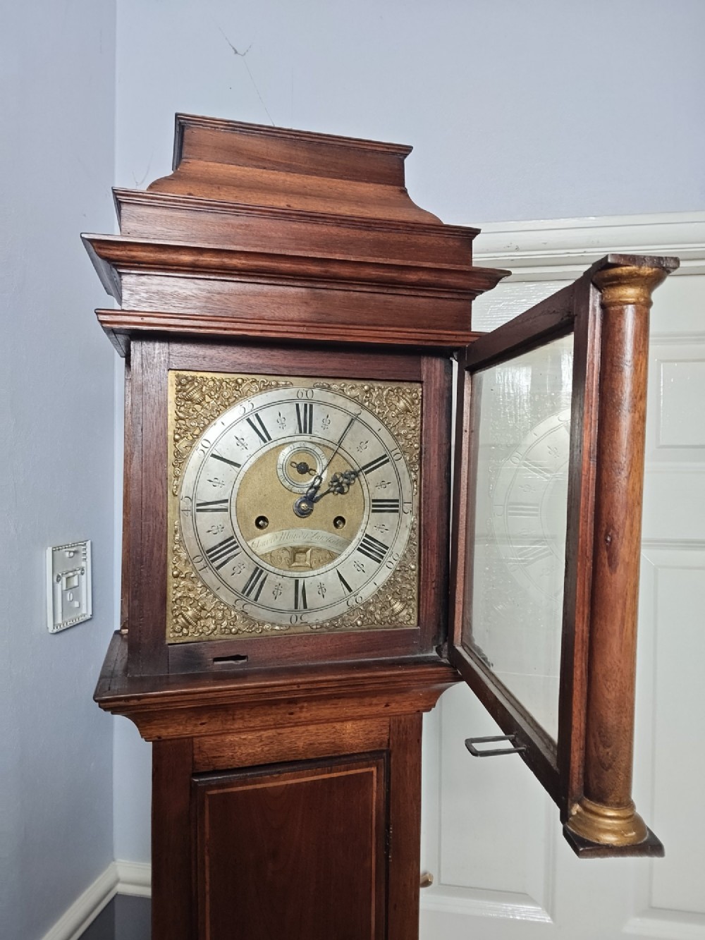 A tall Georgian mahogany longcase clock featuring a square brass dial, starburst marquetry inlay on the trunk door, and a stepped top pediment. View IV