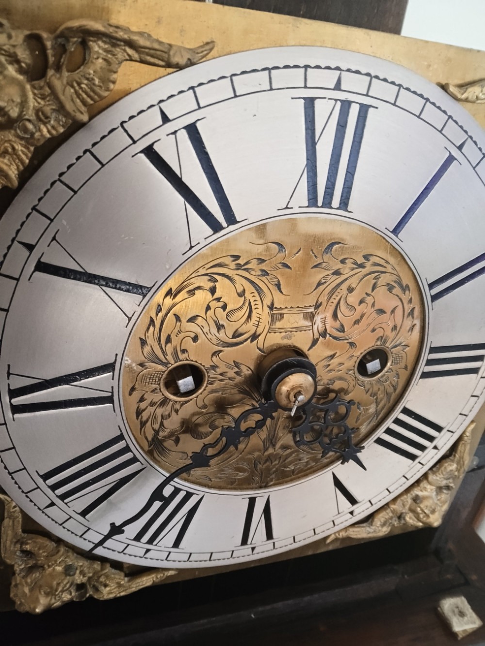 A 19th-century dark oak grandmother clock featuring barley twist side pillars, a square glass hood, and a brass dial with Roman numerals. View V