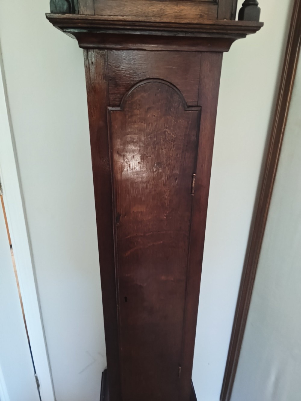A 19th-century dark oak grandmother clock featuring barley twist side pillars, a square glass hood, and a brass dial with Roman numerals. View X