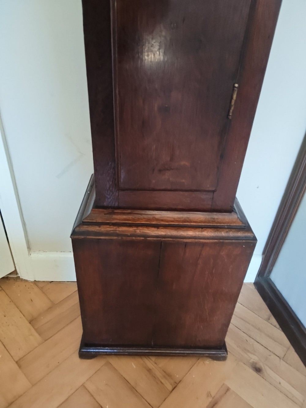 A 19th-century dark oak grandmother clock featuring barley twist side pillars, a square glass hood, and a brass dial with Roman numerals. View XI