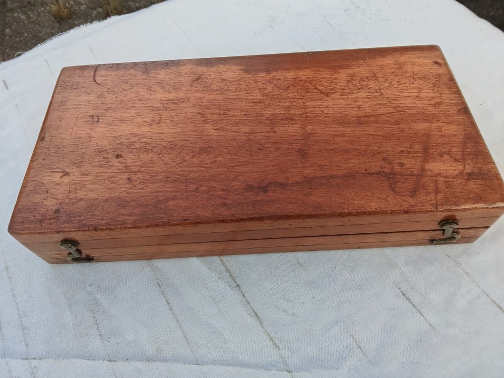 An open antique mahogany folding travelling chess board containing miniature carved red and natural white bone chess pieces fitted into individual pegged holes. View III