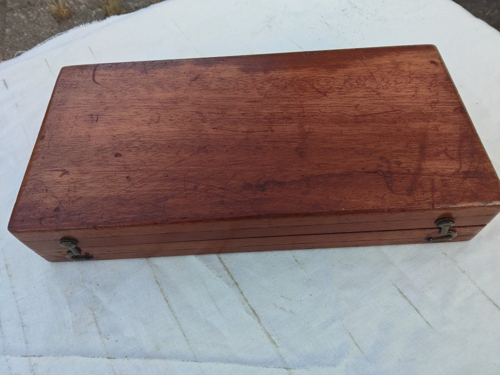 An open antique mahogany folding travelling chess board containing miniature carved red and natural white bone chess pieces fitted into individual pegged holes. View IV