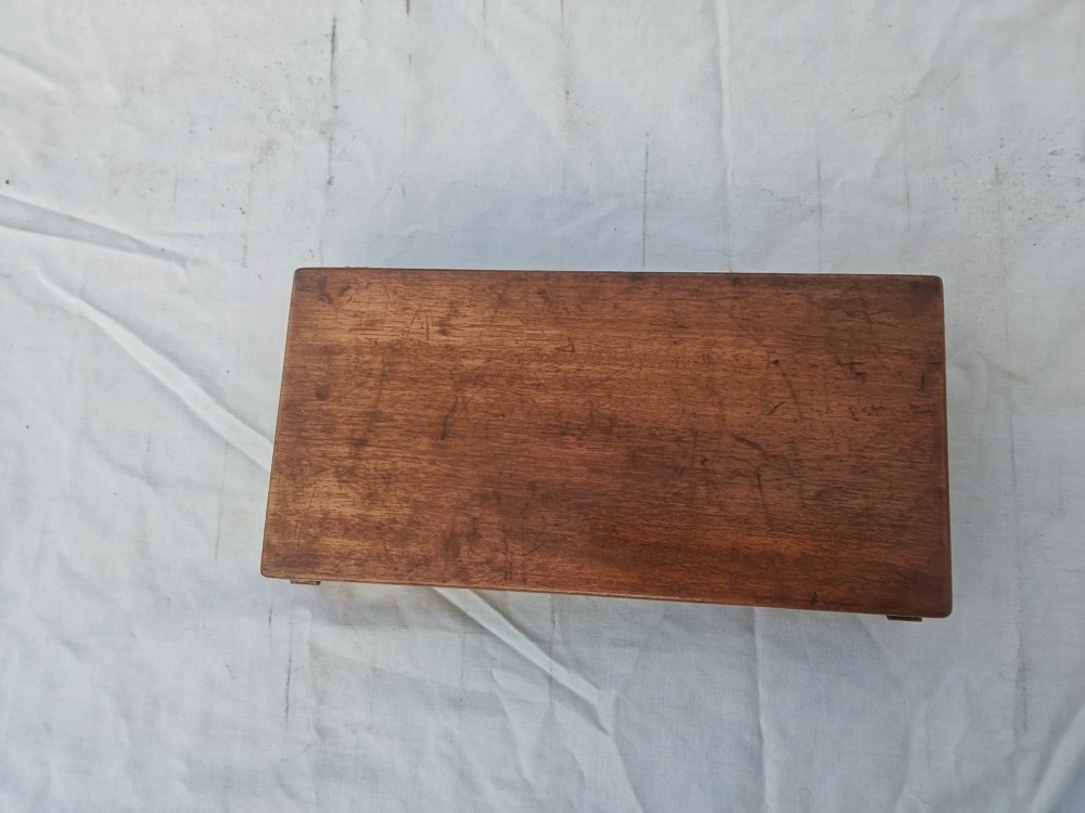 An open antique mahogany folding travelling chess board containing miniature carved red and natural white bone chess pieces fitted into individual pegged holes. View VI