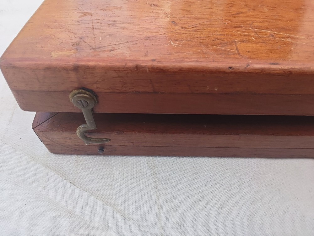 An open antique mahogany folding travelling chess board containing miniature carved red and natural white bone chess pieces fitted into individual pegged holes. View VIII