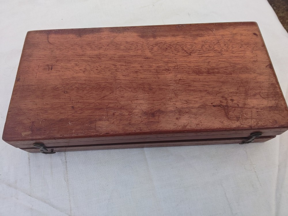 An open antique mahogany folding travelling chess board containing miniature carved red and natural white bone chess pieces fitted into individual pegged holes. View XII
