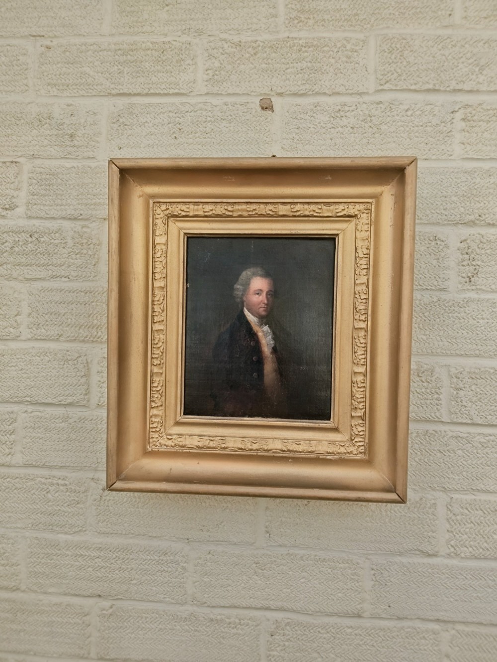 A nineteenth-century oil portrait of a gentleman dressed in period attire set within a deep gilded moulded wooden frame.