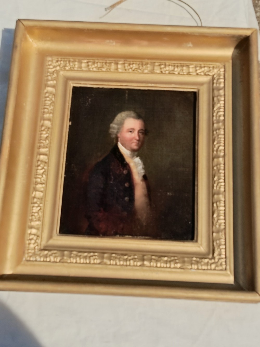 A nineteenth-century oil portrait of a gentleman dressed in period attire set within a deep gilded moulded wooden frame. View XI