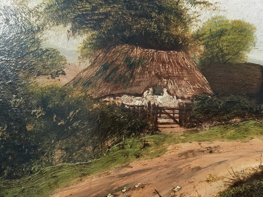 An antique oil painting on card depicting a rural English thatched cottage along a dirt path, set inside an ornate gilt frame. View III