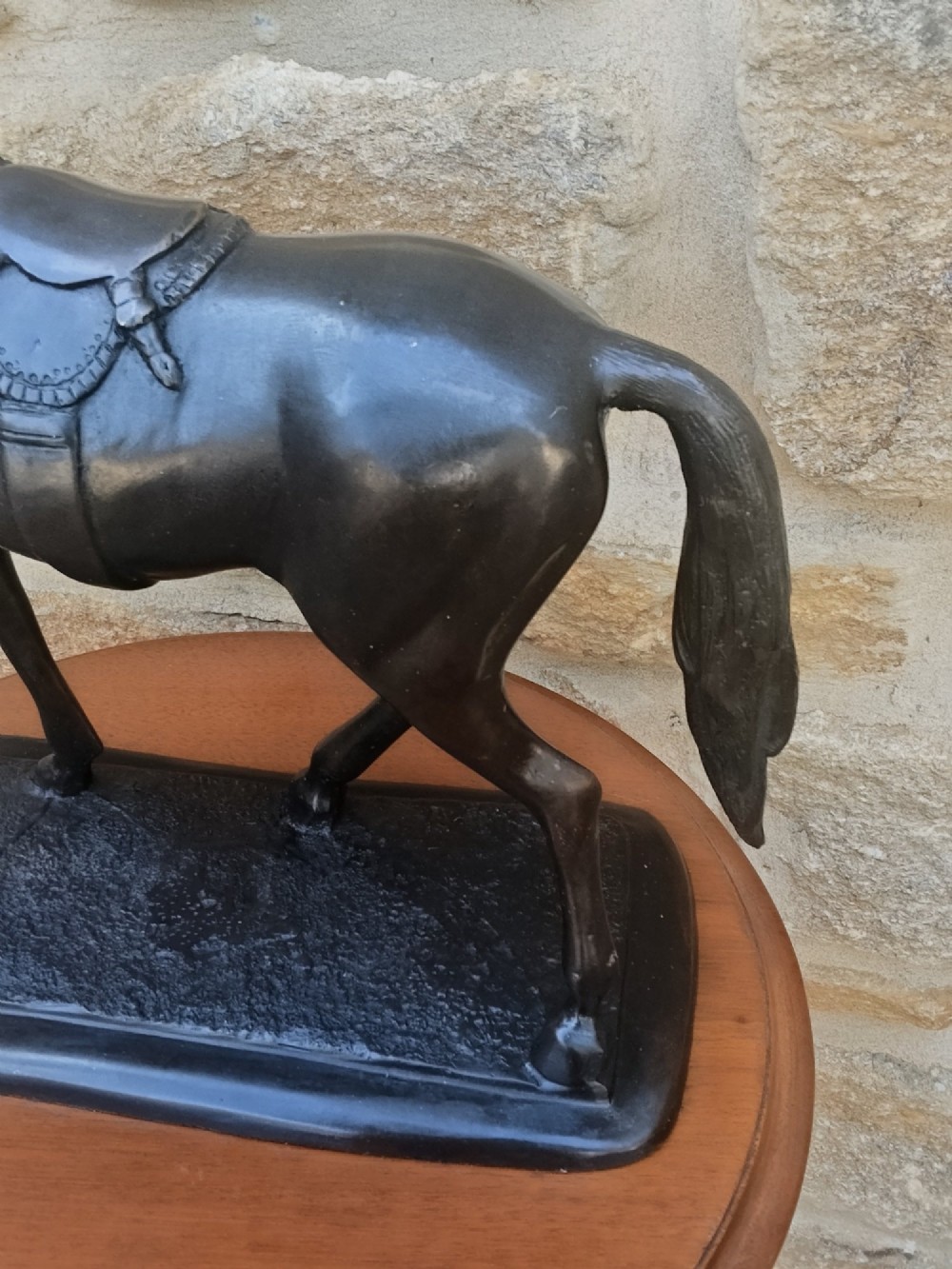 A dark brown cast bronze sculpture depicting a saddled standing horse positioned on an integral rectangular base. View X