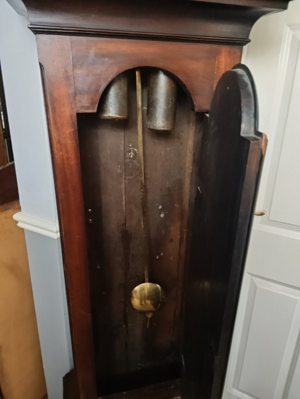 An antique Georgian longcase clock in dark mahogany featuring an arched hood and a brass dial with a strike-silent selector. View IX