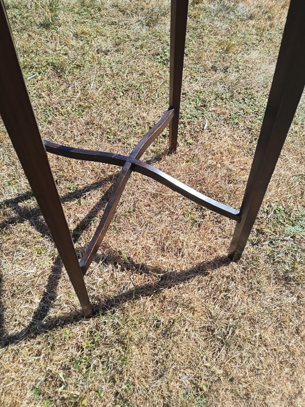 An octagonal dark mahogany side table featuring crossbanded timber inlay around the top surface and four tapered legs supported by an X-shaped stretcher. View VI