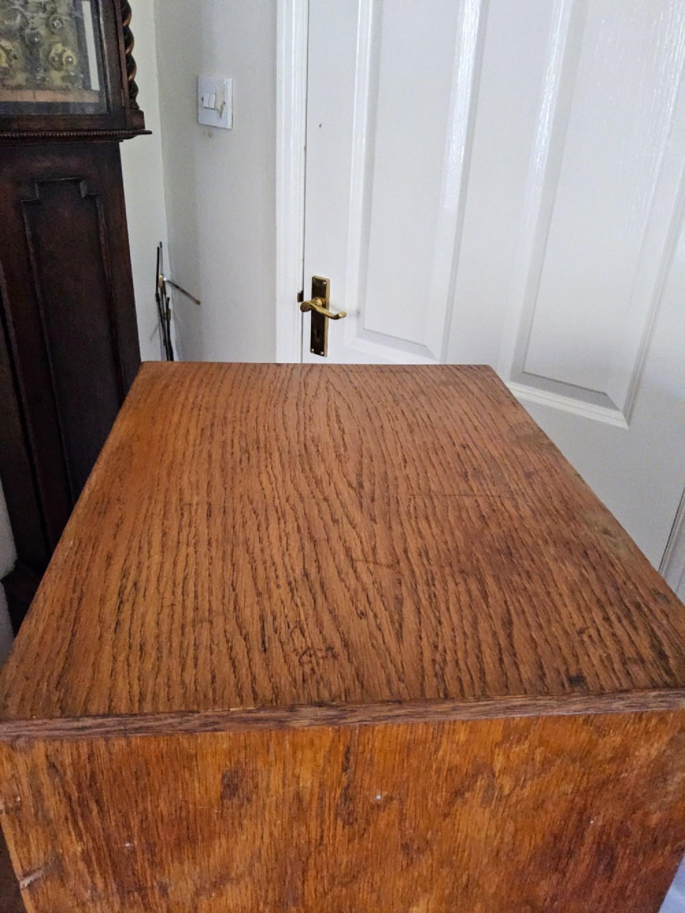A tall oak tambour filing cabinet featuring a slatted wooden roll-front shutter door with a key inserted near the upper handle. View VIII