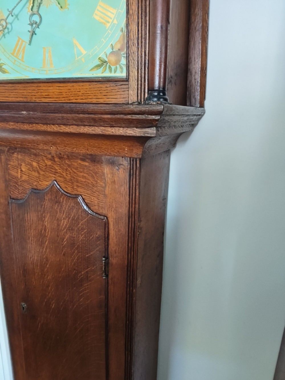 A Georgian oak longcase clock featuring a swan-neck pediment, arched trunk door, and a painted duck egg blue square dial with Roman numerals. View VI
