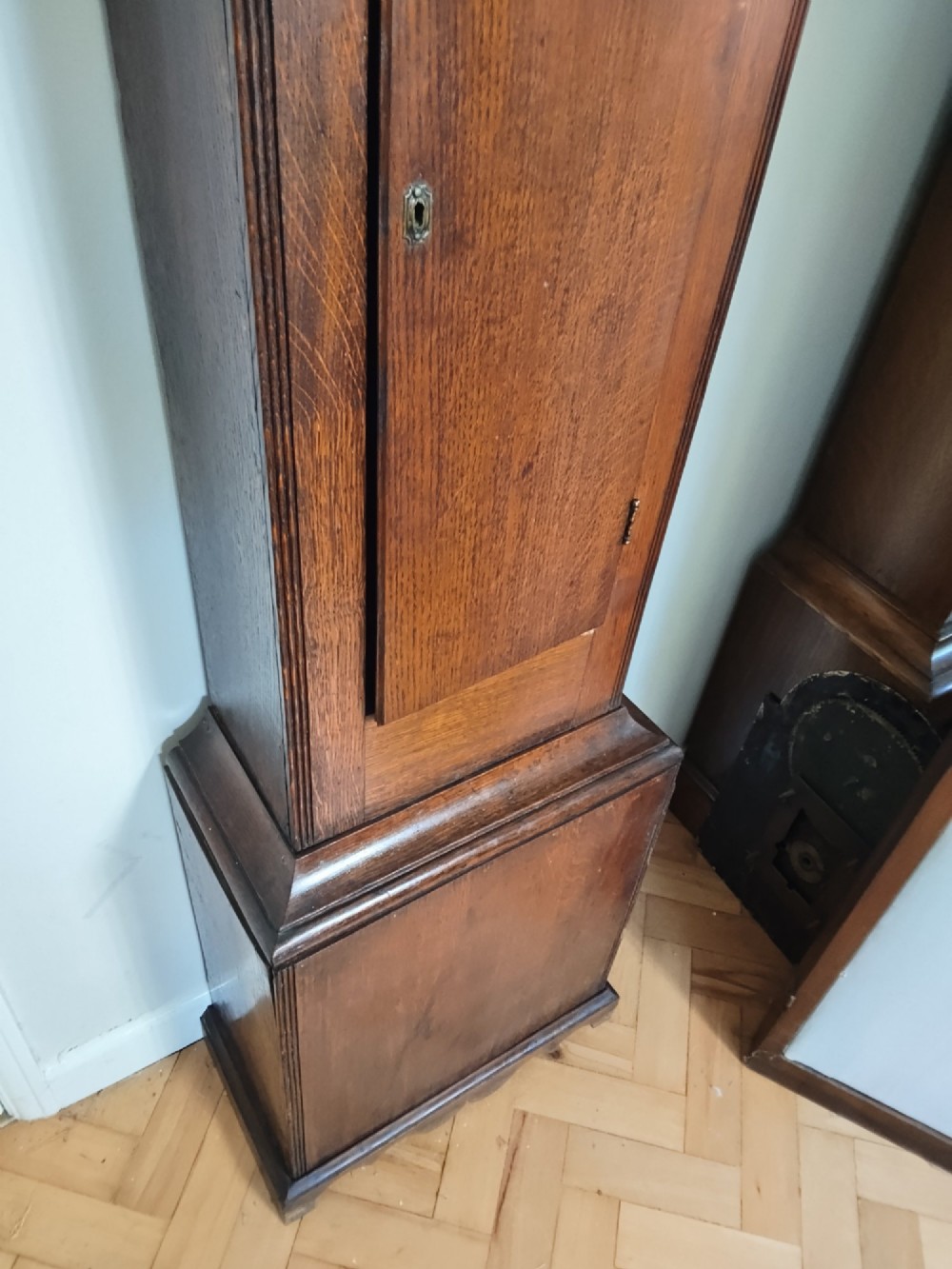 A Georgian oak longcase clock featuring a swan-neck pediment, arched trunk door, and a painted duck egg blue square dial with Roman numerals. View VII