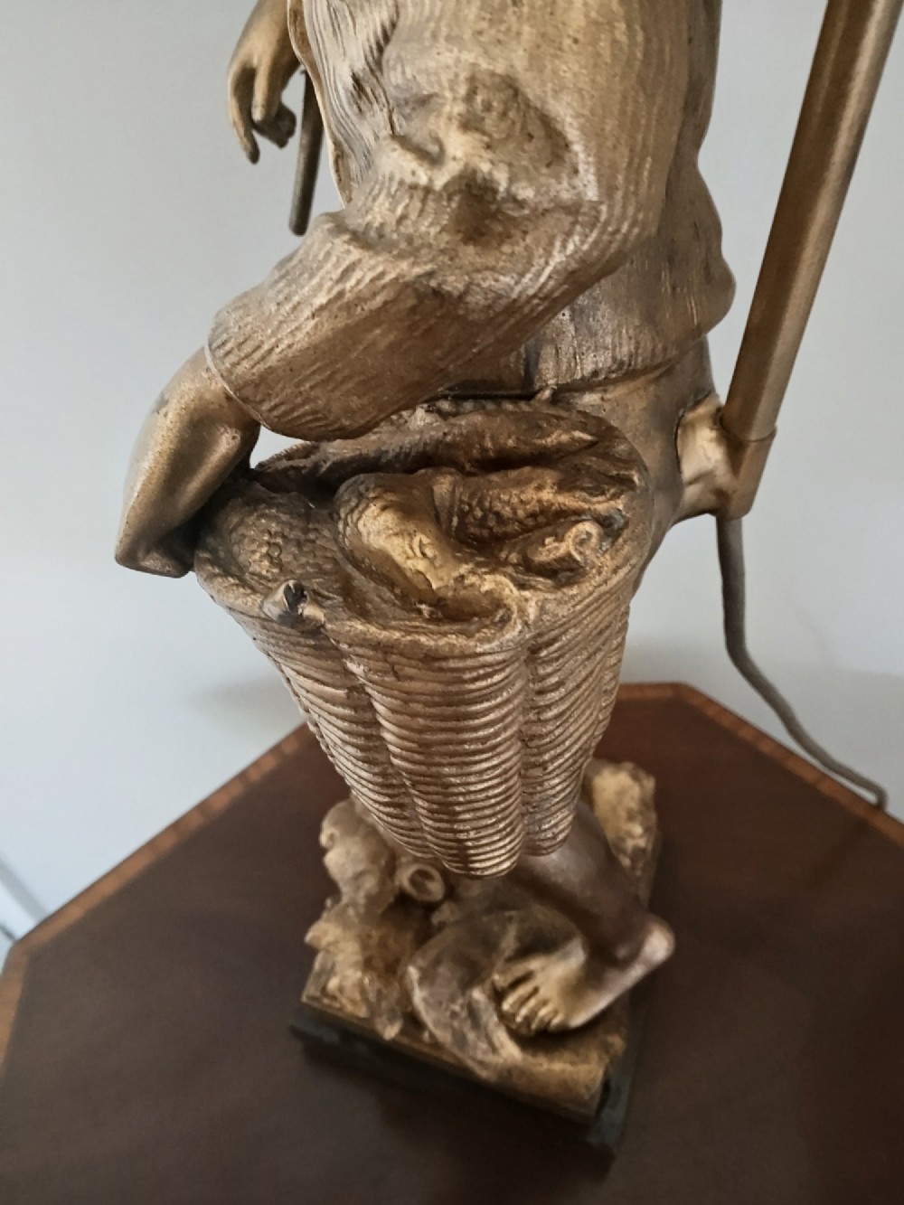 A pair of gold gilt metal table lamps depicting standing figures of French rustic workers mounted on square wooden bases. View V