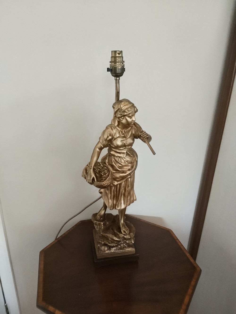 A pair of gold gilt metal table lamps depicting standing figures of French rustic workers mounted on square wooden bases. View X